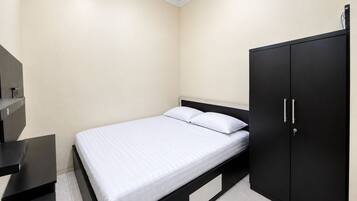 A bedroom with a bed, a wardrobe, and a desk.