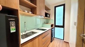 Eine kleine Küche mit Kühlschrank, Spüle und Fenster.