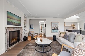 A modern living room with a fireplace, a round coffee table, and a sofa. - Premium Matakana Getaway Close to Matakana Village (Matakana)