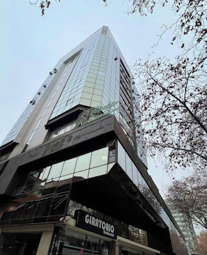 Ein modernes Hochhaus mit einem markanten Restaurant namens 'GIRATORIA' im Erdgeschoss.