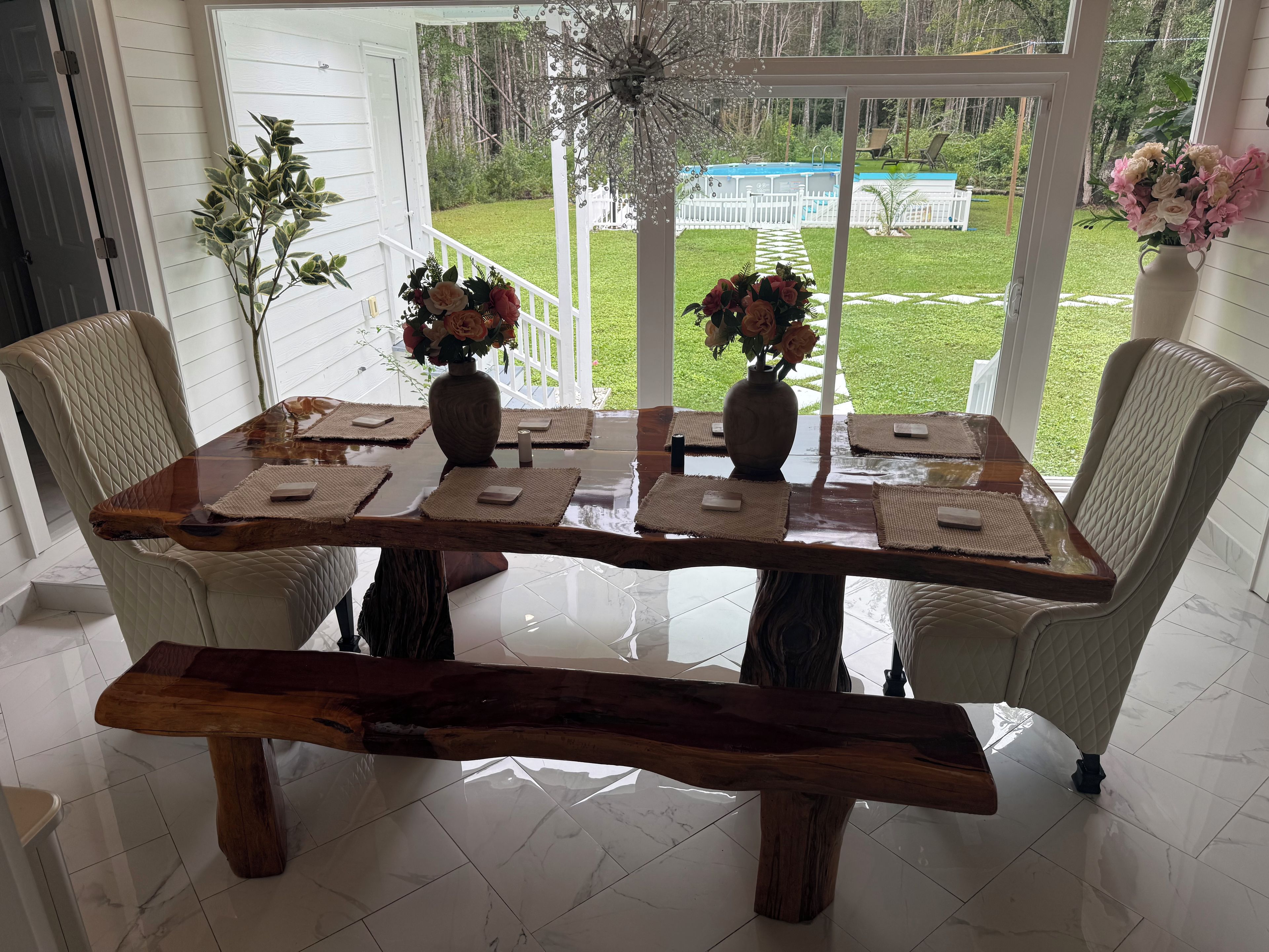 A dining area with a wooden table, cushioned chairs, and a bench.