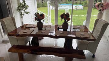 A dining area with a wooden table, cushioned chairs, and a bench.