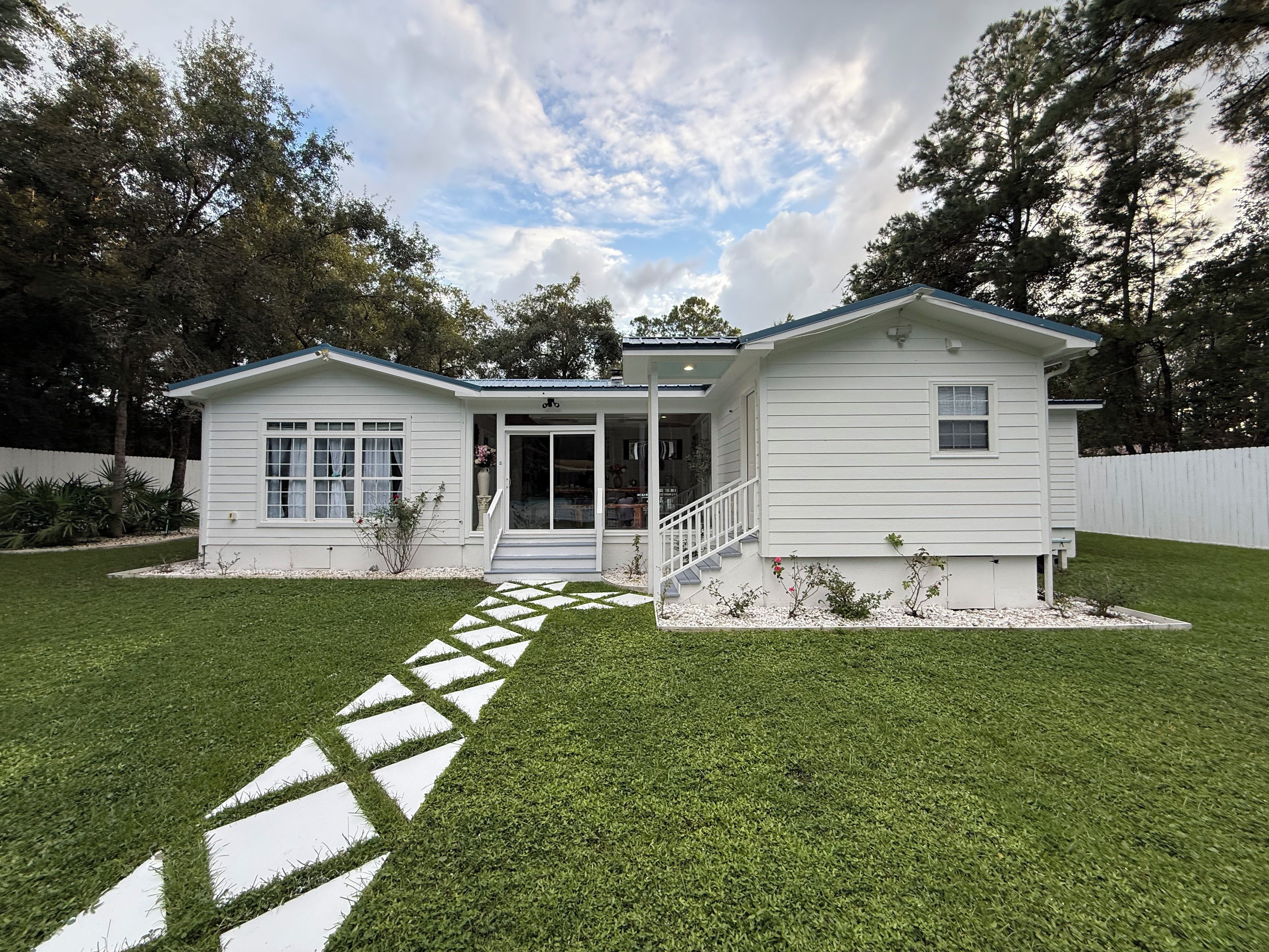 A single-story house with a front porch, a covered entryway, and a small front yard with a stepping stone path.