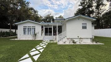 A single-story house with a front porch, a covered entryway, and a small front yard with a stepping stone path.