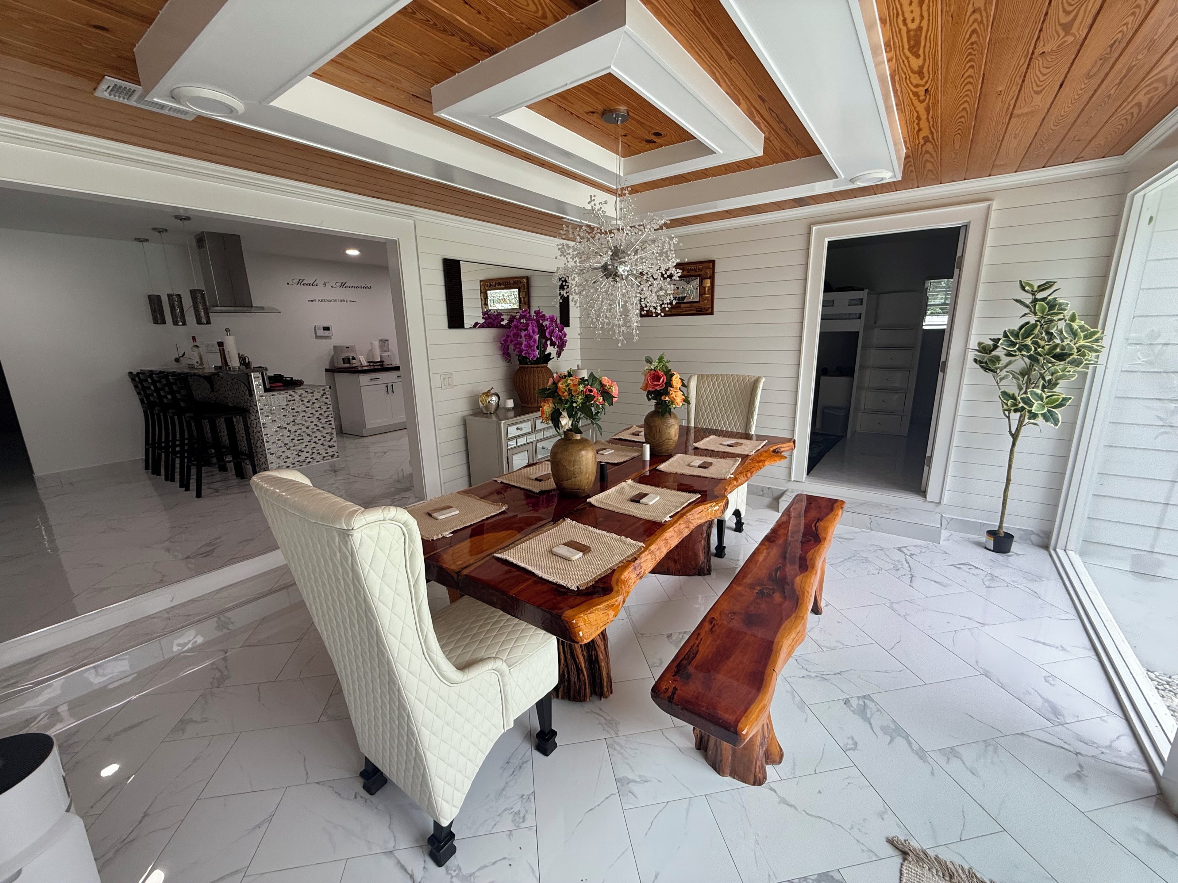 Un comedor con una mesa de madera, sillas acolchadas y un banco.