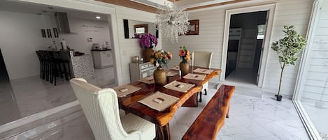 Un comedor con una mesa de madera, sillas acolchadas y un banco.