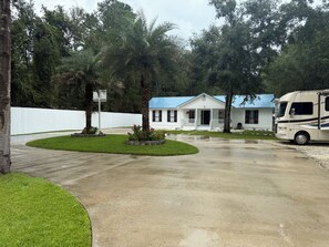 A residential area with a white house, a parked RV, and a white fence. - Spacious 1 acre property with a 6 bedrooms house in charming Brunswick with AC. (Brunswick)