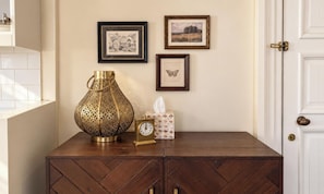 A wooden cabinet with a clock and decorative items on top. - OGB Heritage Loft CBD | Pool, Spa, Gym + Parking (Christchurch)