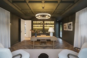 A modern interior with a chandelier, a desk with a lamp, and a seating area. - The Pines Estate, Tallebudgera Valley (Tallebudgera Valley)