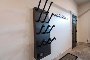A wall-mounted rack with multiple hooks for hanging items, a door with a window, and a power outlet on the wall. - Teton Homestead: Stone Peak Hideaway (Driggs)