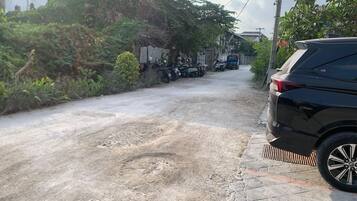 Una carretera pavimentada con un automóvil estacionado y motocicletas.