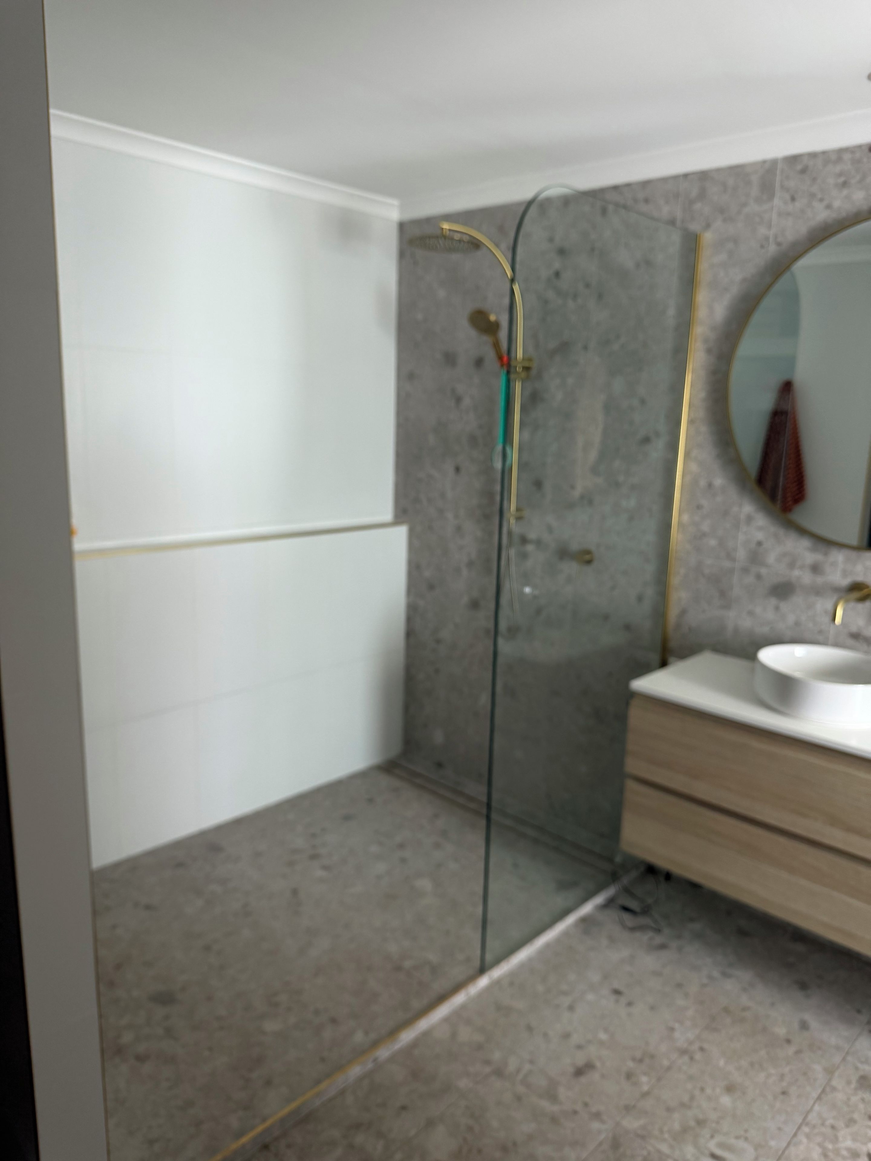 Un baño con ducha, lavabo y espejo.