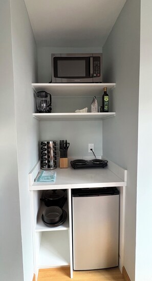 A compact kitchenette with a microwave, coffee maker, and a small refrigerator. - Sweet and Private Apartment Close to Everything Beautiful and Fun! (El Granada)