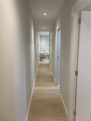 A hallway with wooden flooring, white walls, and a door on the right. - Open-Concept 2-Bedroom Apartment in Puerta de Toledo, Berlany, Spain (Madrid)