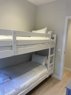 A bunk bed with white bedding and a wooden frame. - Open-Concept 2-Bedroom Apartment in Puerta de Toledo, Berlany, Spain (Madrid)