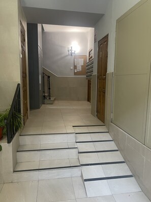 A hallway with a tiled floor, a staircase, and a door on the right. - Open-Concept 2-Bedroom Apartment in Puerta de Toledo, Berlany, Spain (Madrid)