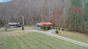 A rural property with two houses, a paved driveway, and a well-maintained lawn. - Wolf's Den Creekside Cabin (Bryson City)