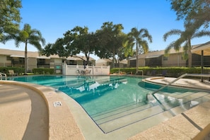 A swimming pool with a clear blue water surface, surrounded by a sandy deck and a white fence. - The Quiet Oak - Peaceful South Tampa Condo w/ Pool and Reflection Pond (Tampa)