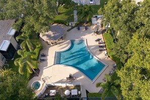 An aerial view of a resort with a large swimming pool, lounge chairs, and palm trees. - The Quiet Oak - Peaceful South Tampa Condo w/ Pool and Reflection Pond (Tampa)