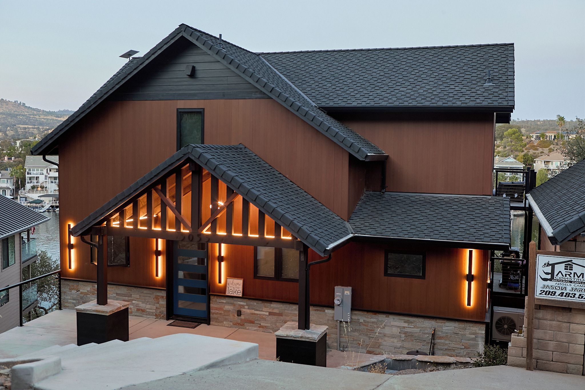 A two-story building with a sloped roof, a wooden facade, and a stone foundation.