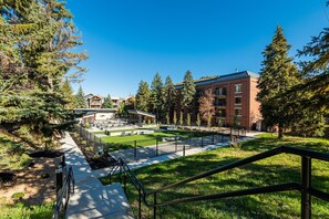 A courtyard with a central lawn, surrounding buildings, and a clear sky. - Historic Old Town 2BR/2BA condo with hot tub, pool, sauna & walk-to-lift access. (Park City)
