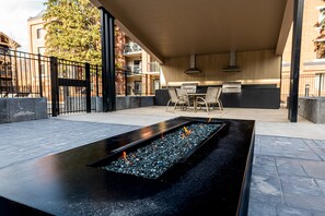 An outdoor patio area with a rectangular water feature, a grill, and a seating arrangement. - Historic Old Town 2BR/2BA condo with hot tub, pool, sauna & walk-to-lift access. (Park City)