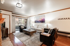A modern living room with a sofa, armchairs, a coffee table, and a painting on the wall. - Historic Old Town 2BR/2BA condo with hot tub, pool, sauna & walk-to-lift access. (Park City)