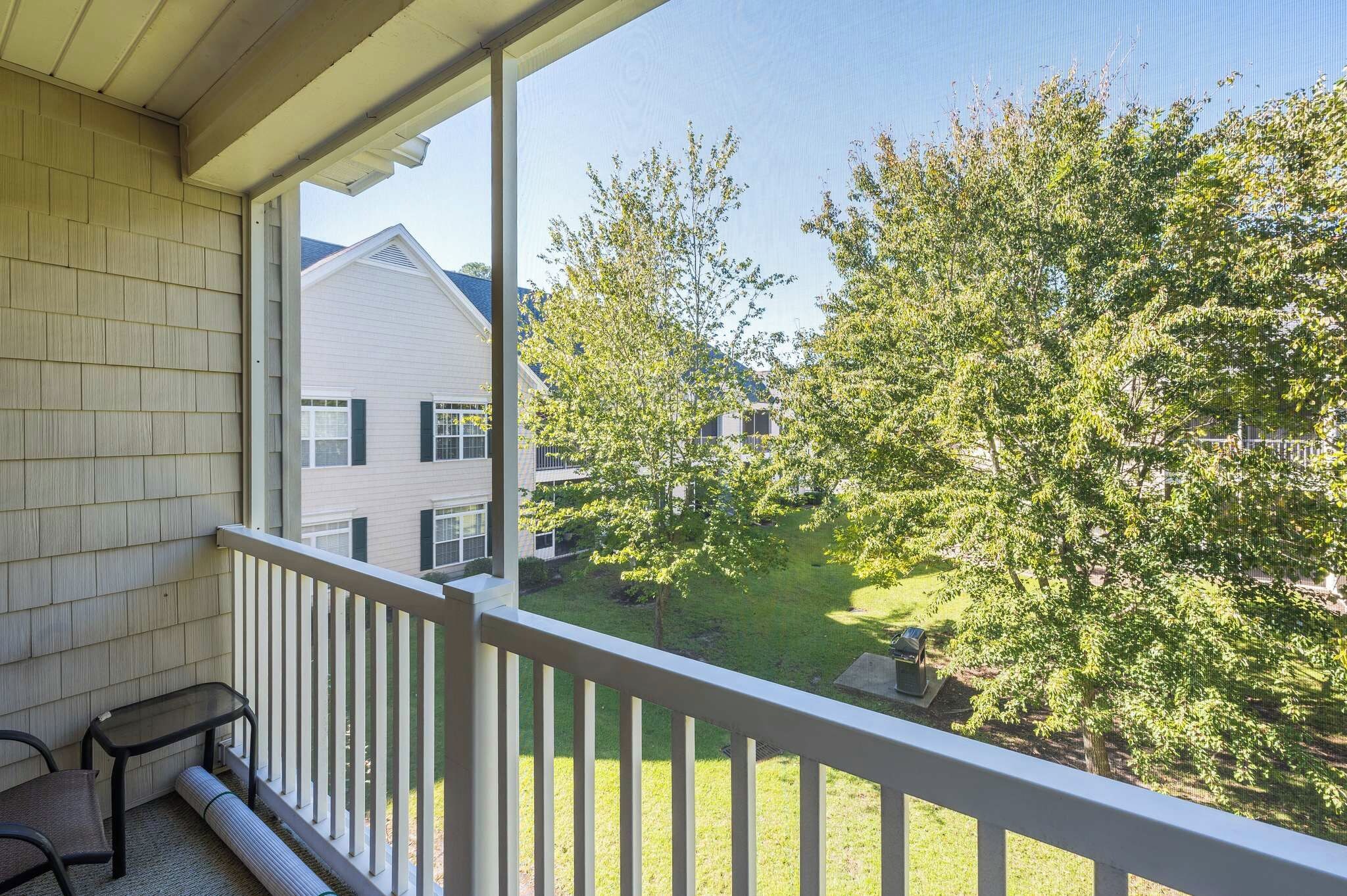 Un balcón con vistas a una zona residencial, una mesita y una silla.