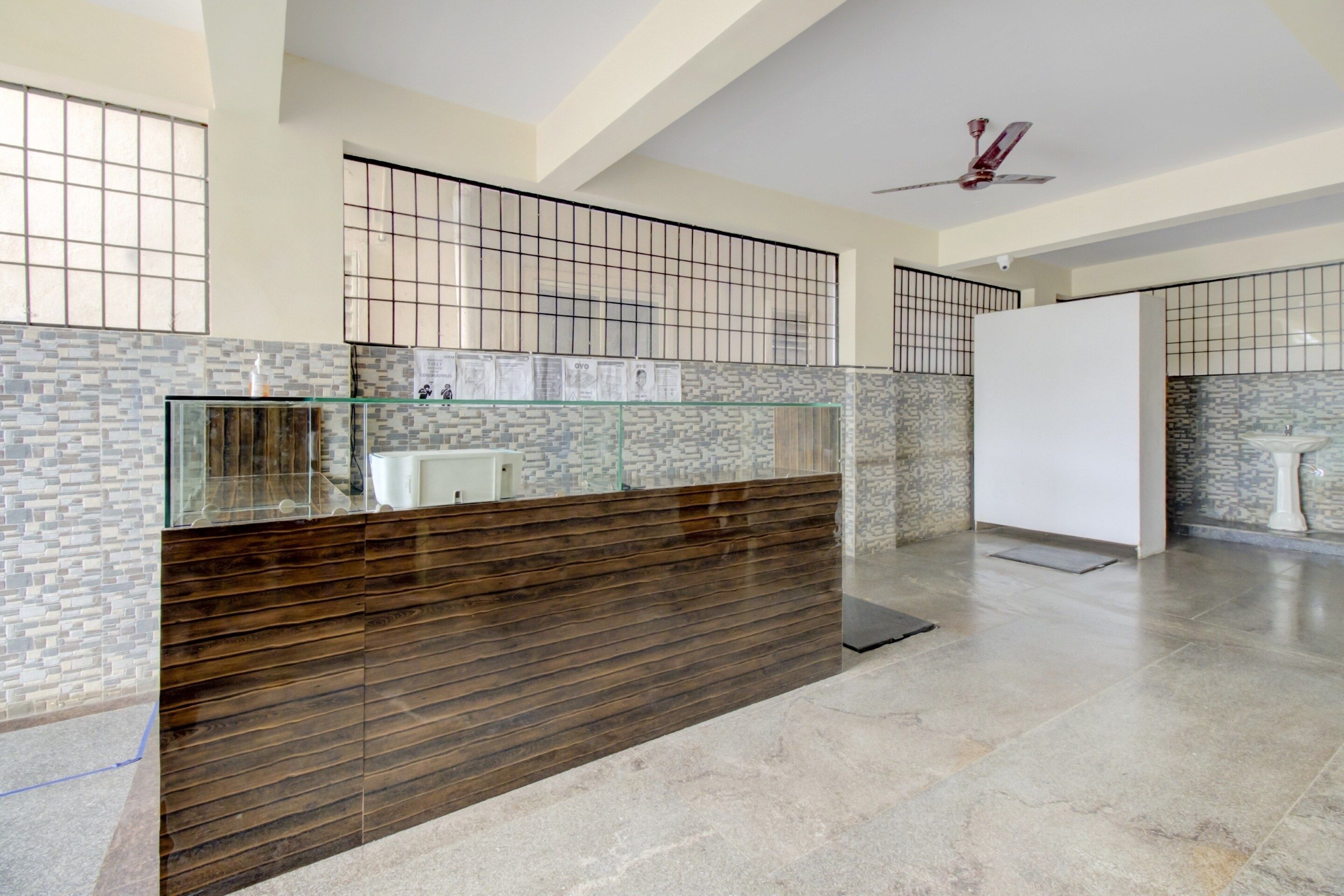 Una cocina moderna con encimera de vidrio, paneles de madera y un salpicadero de azulejos.