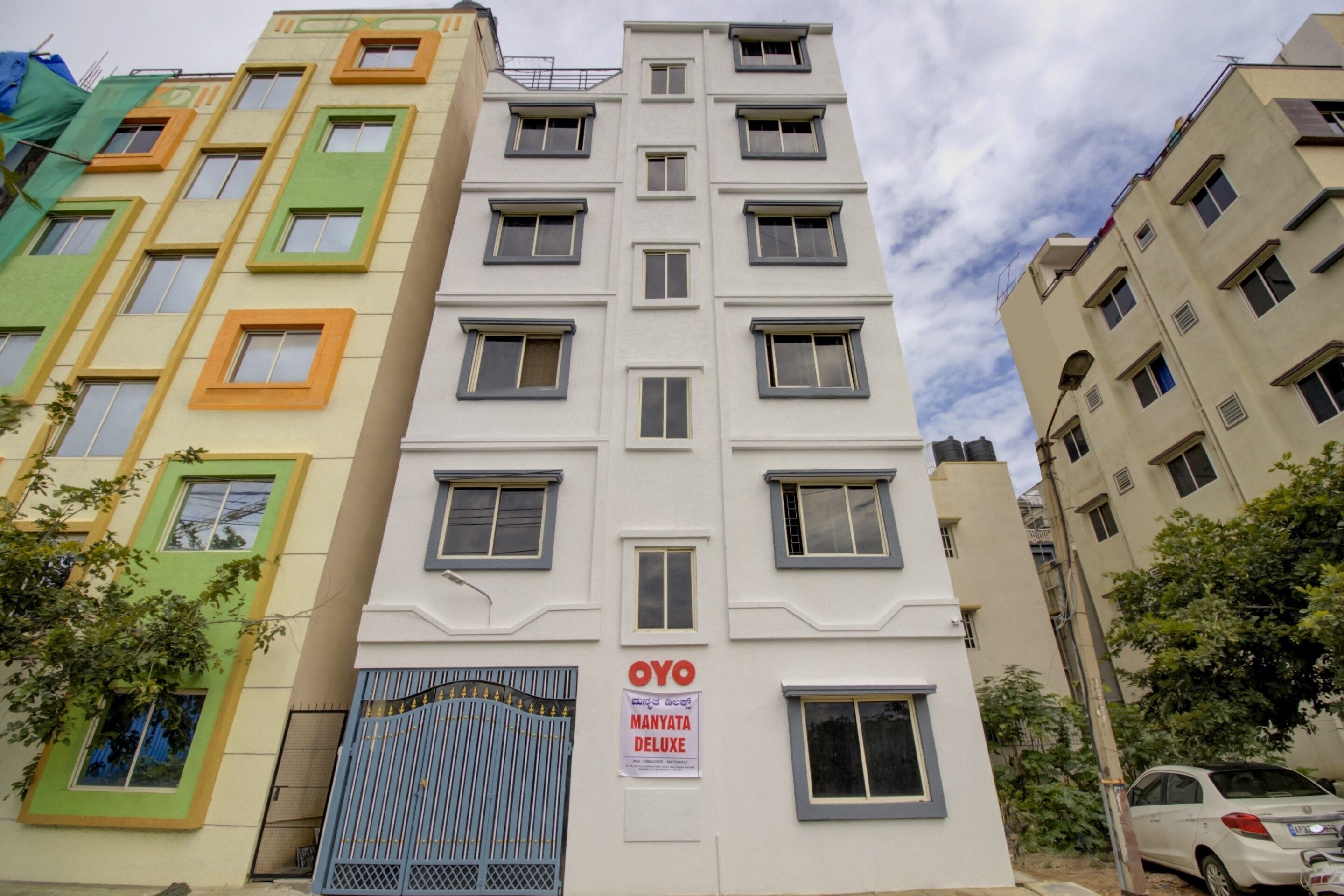 Un edificio de varios pisos con un letrero que indica 'MANYATA DELUXE' hotel.