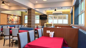 A restaurant interior with booths, tables, and a large window.