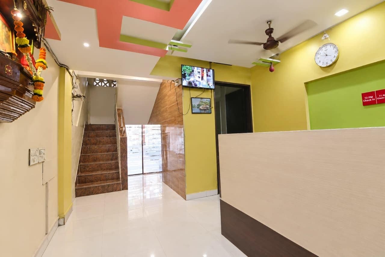 A reception area with a reception desk, a clock, and a television on the wall.