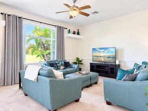 A living room with a sofa set, a television, and a ceiling fan. - Rotonda Golf Course Villa with Pool & Hot Tub (Rotonda West)