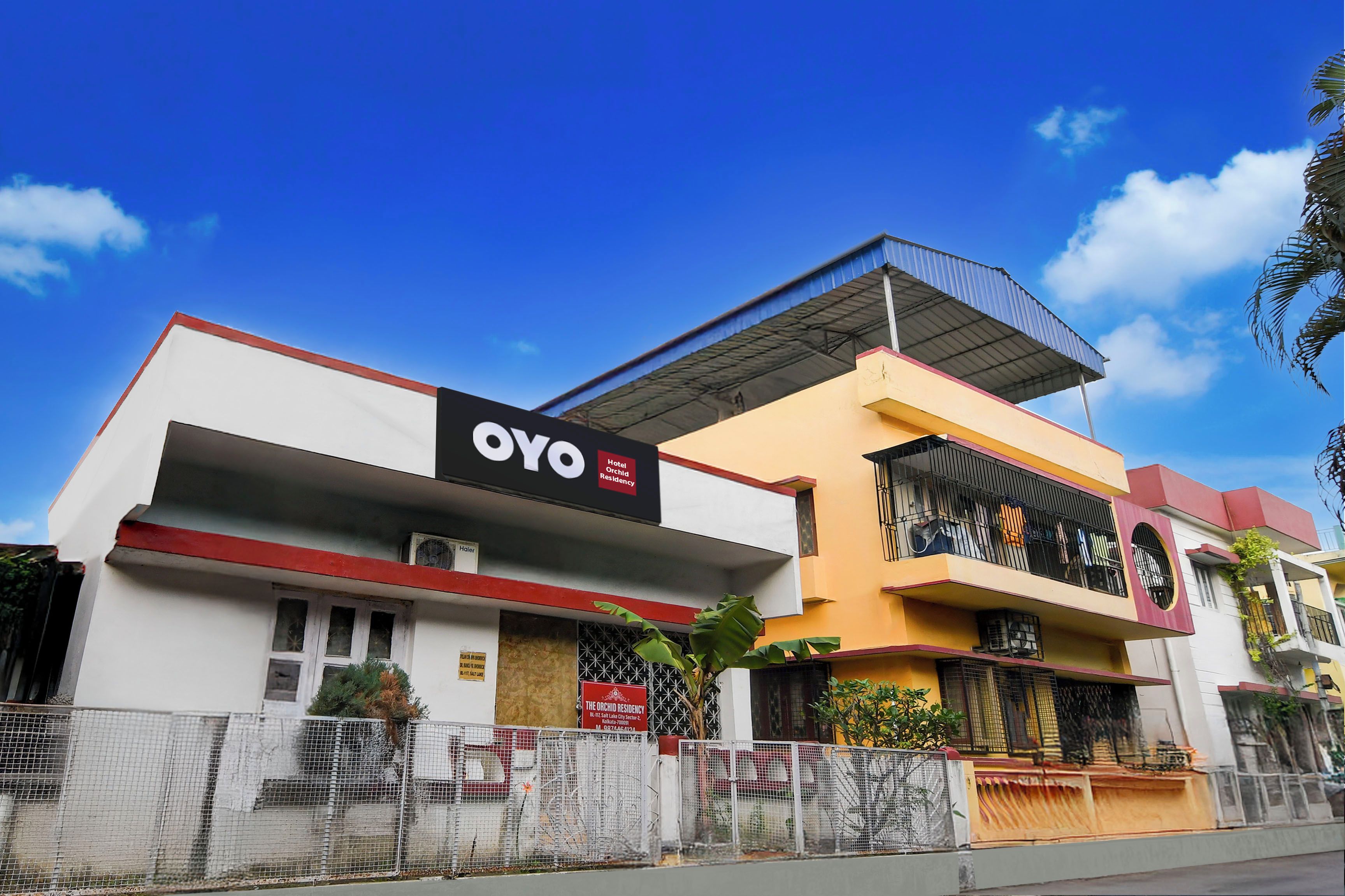 Un hotel llamado 'OYO' con un letrero que indica que es hotel y residencia de orquídeas.