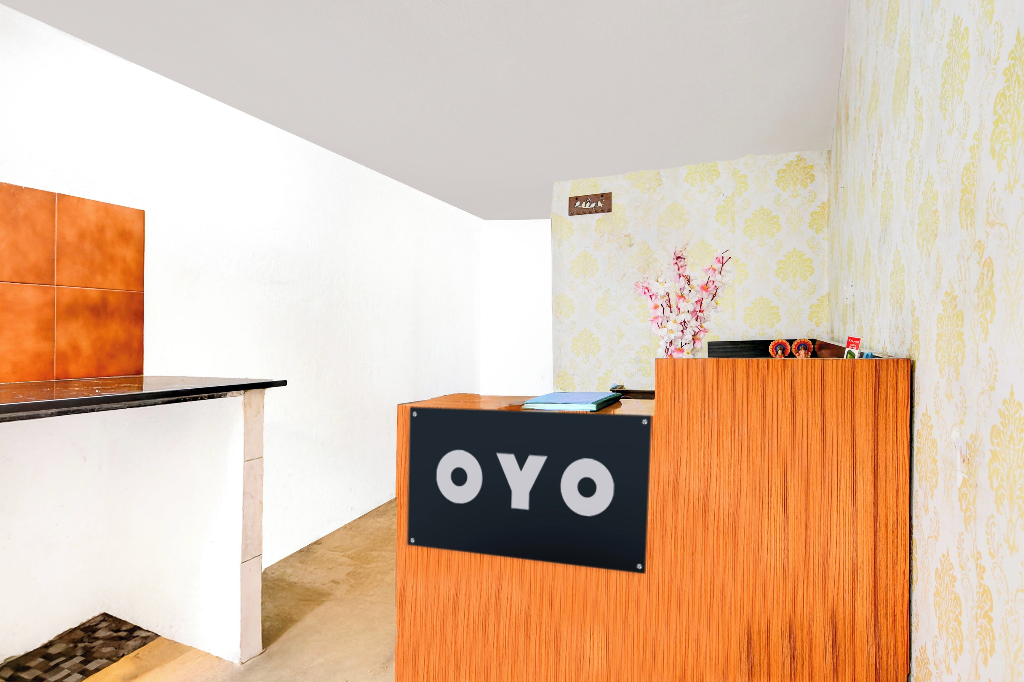 Una recepción con un cartel que dice 'OYO' en un moderno vestíbulo de hotel.