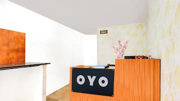 Una recepción con un cartel que dice 'OYO' en un moderno vestíbulo de hotel.