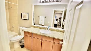Une salle de bain avec un lavabo, des toilettes et une douche.