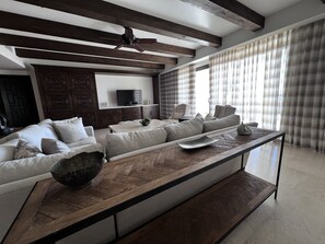 A modern living room with a sofa set, a coffee table, and a television.