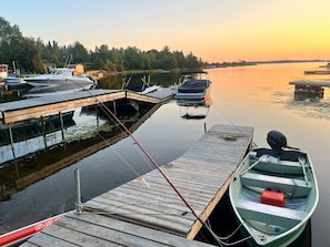 A calm lake with boats docked at wooden piers, surrounded by trees. - Private Georgian Bay Waterfront Cottage: Dock, Sand Beach, Hot Tub, Dogs OK (Tay)