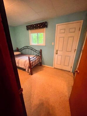 A bedroom with a single bed, a window, and a door. - Private Georgian Bay Waterfront Cottage: Dock, Sand Beach, Hot Tub, Dogs OK (Tay)