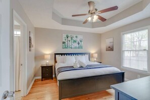 A bedroom with a bed, a nightstand, a ceiling fan, and artwork on the walls. - Big Backyard | Mins to Downtown | 3BR Sleeps 8 (Nashville)