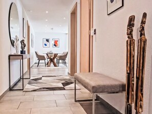 A modern interior with a bench, a dining area with chairs, and a large mirror. - Kanzi, St. Anton by Interhome (Sankt Anton am Arlberg)
