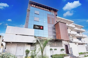 A modern building with a sign for 'SS ENTERPRISES' and a 'Collection Hotel Star Inn' sign.