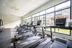 A gym with treadmills, exercise bikes, and a laptop on a desk. - Landing | Chic 2BD, Courtyard, Clubhouse (Fort Wayne)