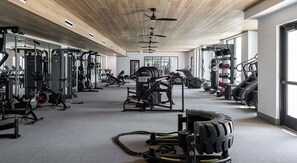 A gym with various exercise equipment, including weight machines, treadmills, and stationary bikes. - Landing | Stylish 1BD in Lochridge (Cary)