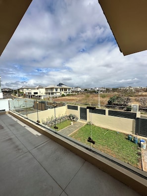 Un barrio residencial con casas, un patio empedrado y vistas a edificios lejanos.