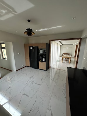 Una cocina moderna con refrigerador, microondas y horno.