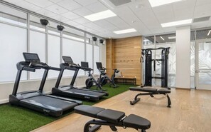 A gym with treadmills, stationary bikes, and a weight machine. - Landing | Beautiful 1BD in West Side (Grand Rapids)