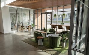 A modern interior with a seating area, a table, and large windows. - Landing | Incredible Studio in West Side (Grand Rapids)