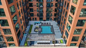 A high-rise building with a rooftop pool area, multiple balconies, and a modern architectural design. - Landing | Stylish 1BD in Central West End (St. Louis)